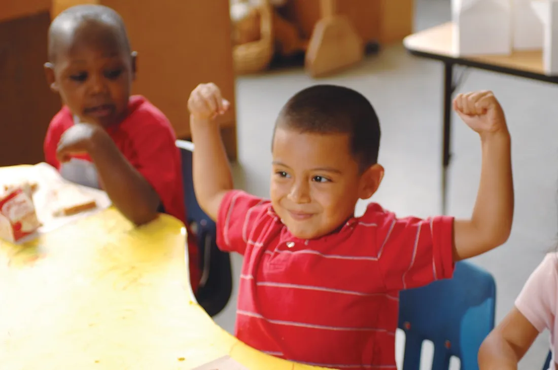 Children celebrate together at a classroom table.